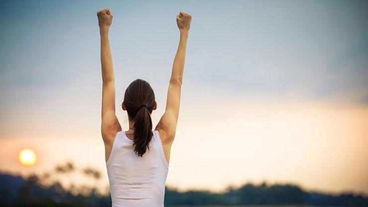 successful woman raising arms in triumph